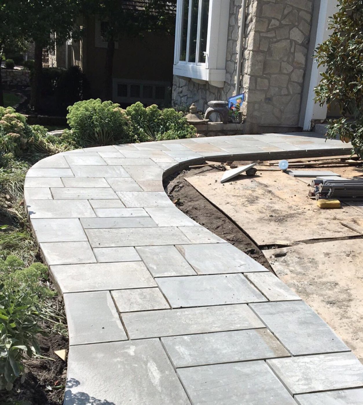 Curving bluestone walkway across a front yard