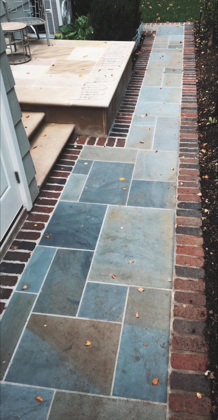 Bluestone walkway edged in brick beside steps