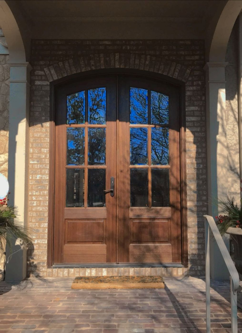 Brick entry porch with arched wood doors