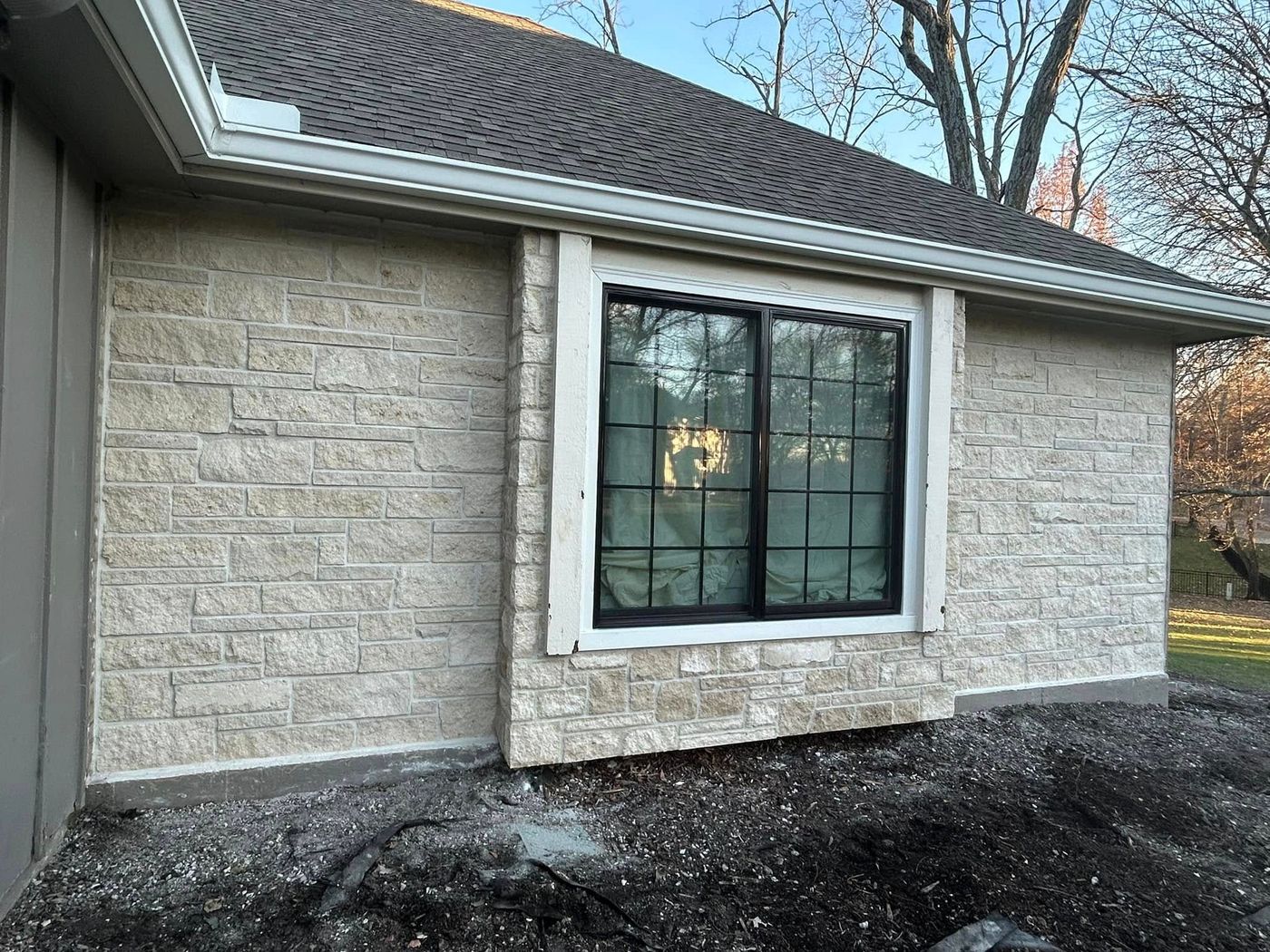 House wall faced in cut stone veneer