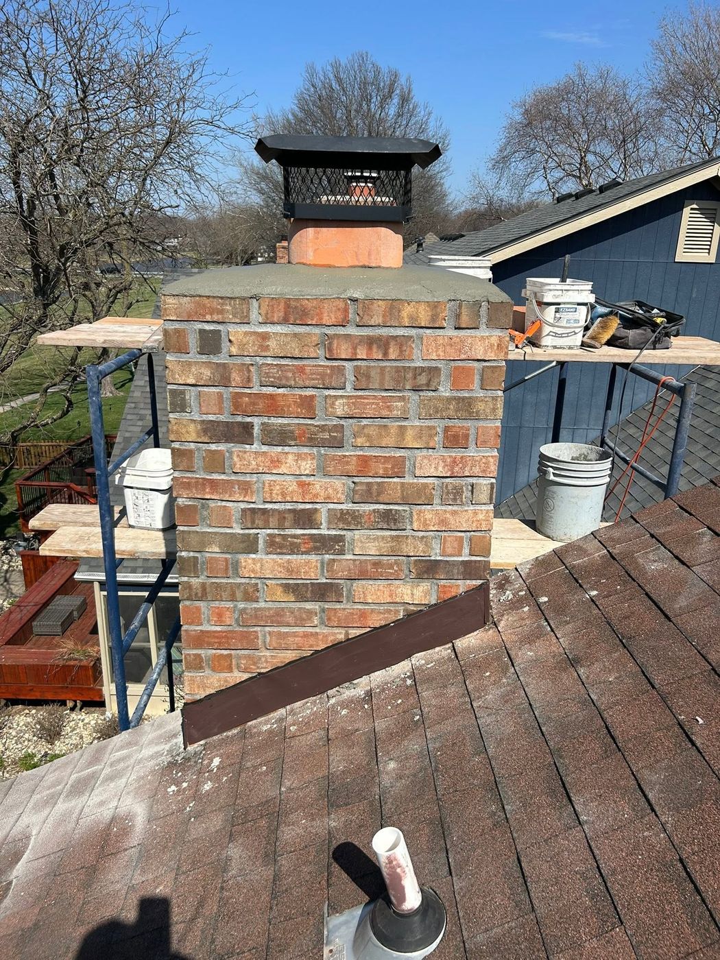 Brick chimney rebuilt on the roof with a new crown and cap