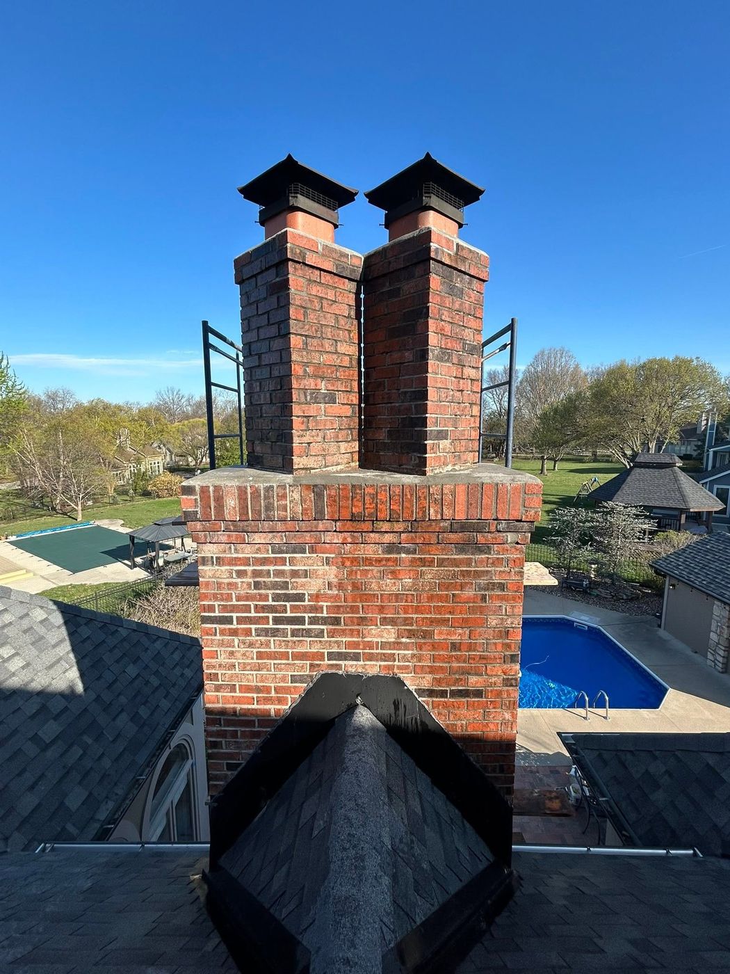 Double flue brick chimney with black caps