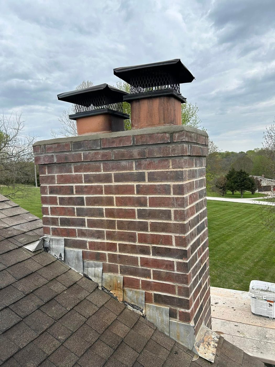 Same chimney stack with a rebuilt crown and clean brickwork