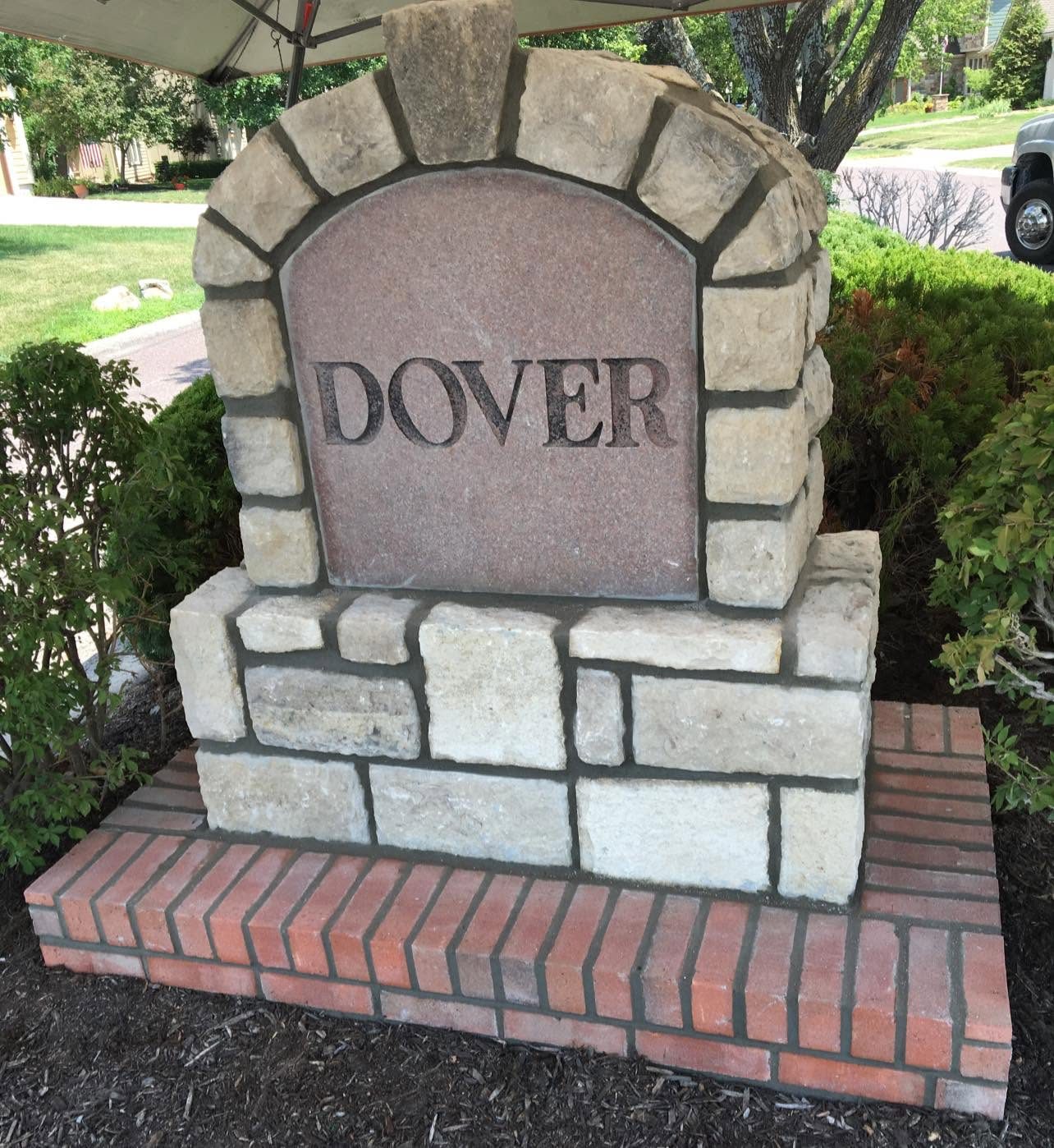 Dover neighborhood entrance sign in cut stone on a brick base
