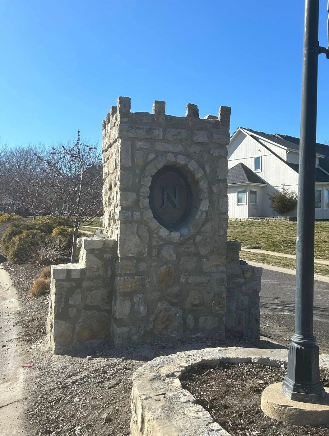 Stone entrance monument with a neighborhood crest