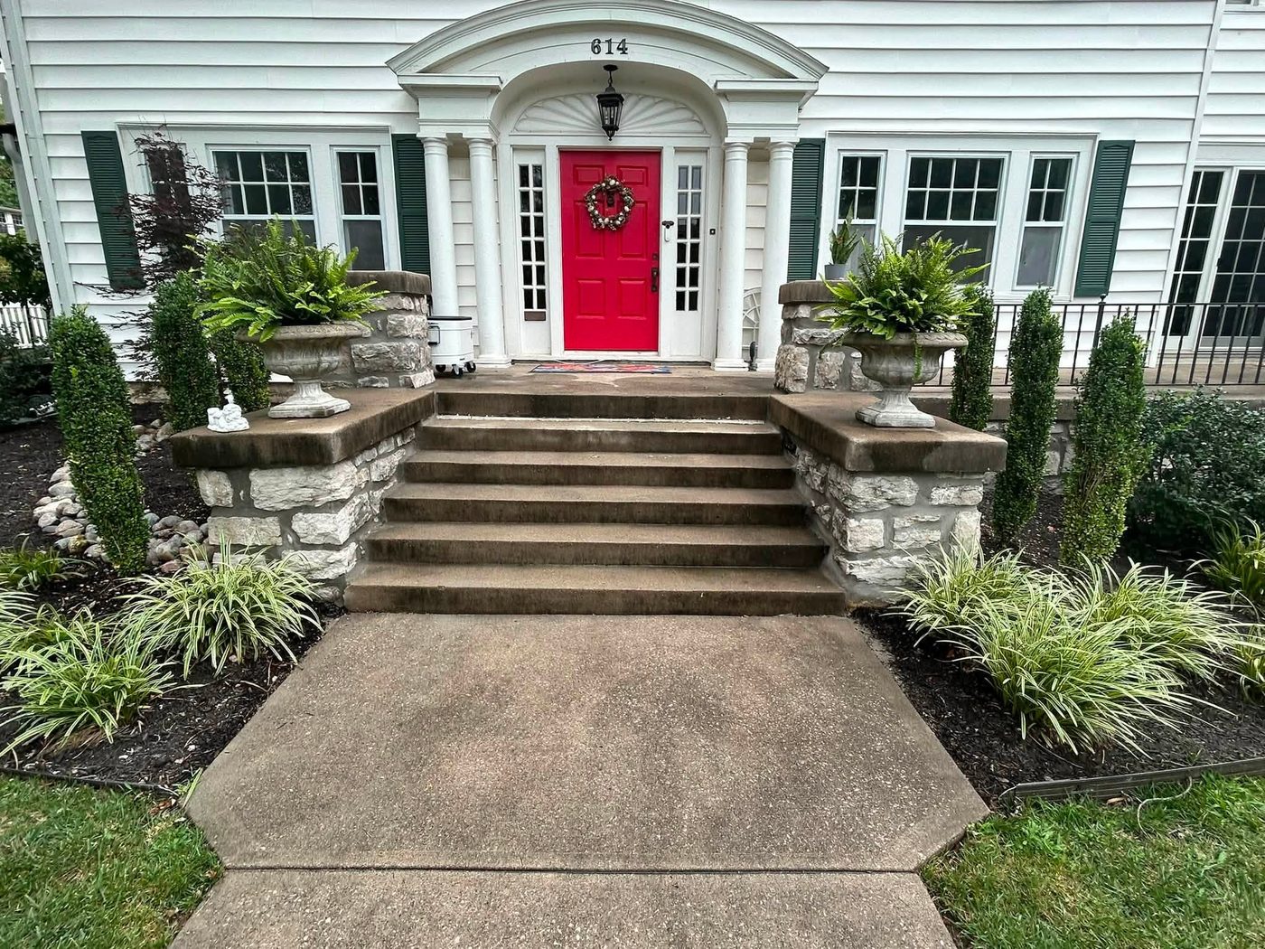 Wide stone entry steps leading to a red front door