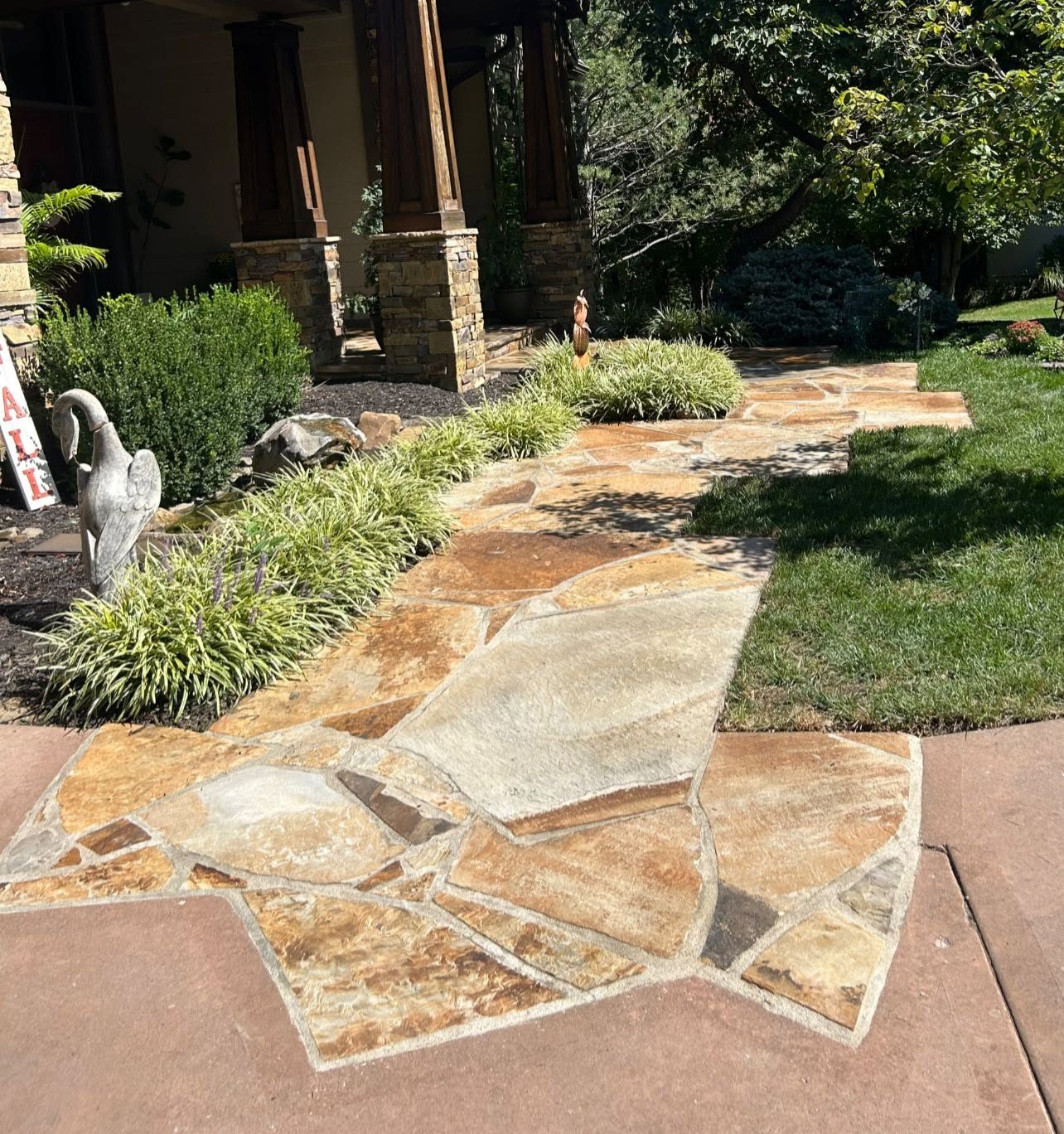 Flagstone walkway leading to a stone-column porch