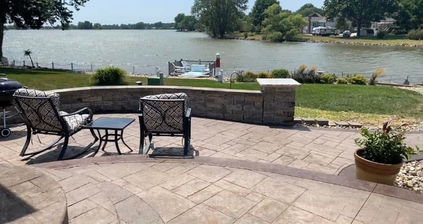 Patio chairs beside the stone seat wall overlooking the lake
