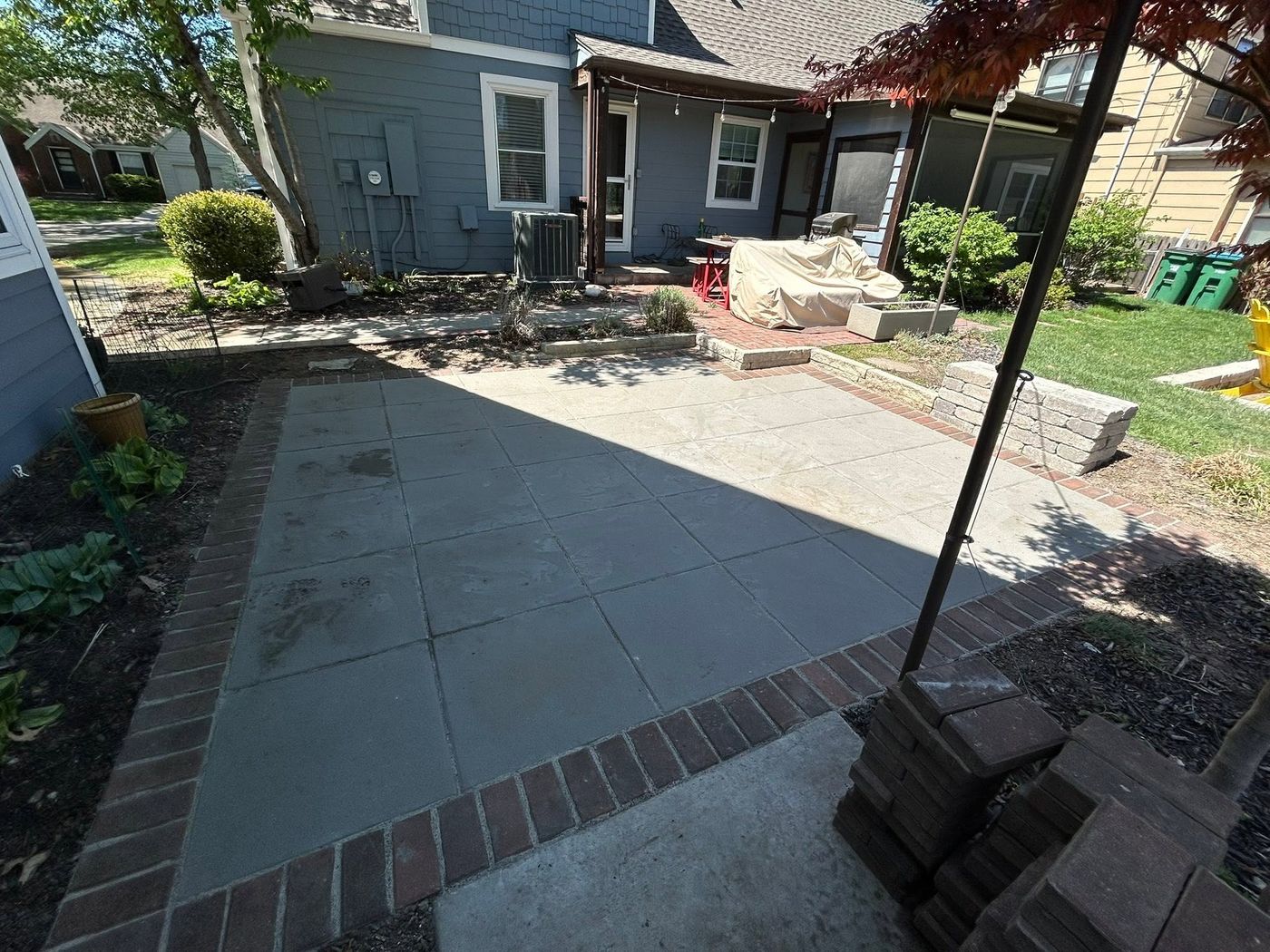 New concrete patio with a brick border