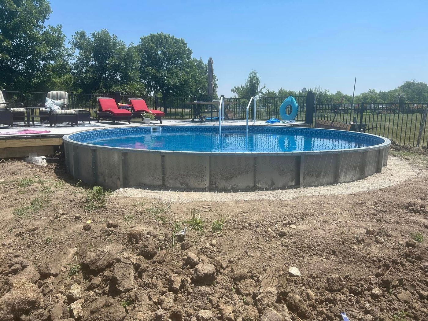 Plain metal pool wall surrounded by dirt