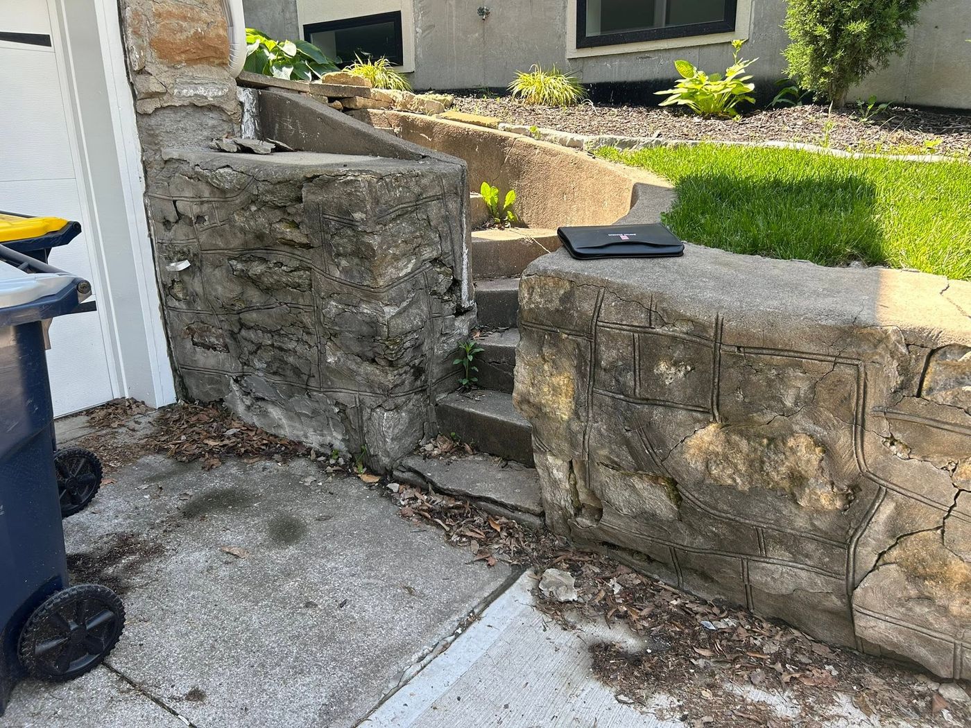 Crumbling stone stairs and walls beside a garage